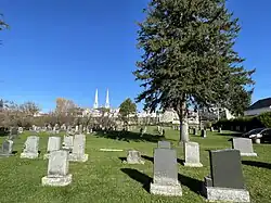 Curé-Adélard-Lamy cemetery, spires of the bell towers of the Catholic church, the village