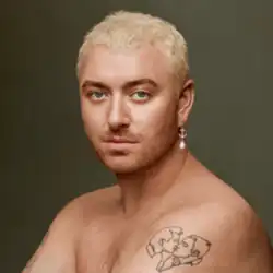 Portrait of Smith with bleached hair, a shoulder tattoo of two men kissing and wearing a golden earring