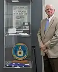 Sherman Wetmore poses next to a collection of Project AZORIAN artifacts on display.
