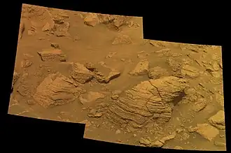 Figure 5. Blocks of Meridiani sediment in the walls of Concepcion Crater. Concepcion Crater is unusually young (roughly 100,000 years). So the exposed layered sediment surfaces imaged here are some of the freshest, least-weathered sediment layers photographed by Opportunitys Pancam. When viewed full size, these Pancam images (Figures 5 & 6) have just enough resolution to show many small hematite spherules embedded in the sediments. Another higher-resolution camera, the Microscopic Imager, took the best images of the hematite spherules (more below). Image taken on Sol 2147 (2010-02-06).