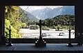 View in 1998 through the central apsidal window of St James Church, looking across the Waiho River with Franz Josef Glacier visible beyond