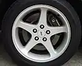 The stock 17x8-inch silver wheels and disc brakes on a 1999 SVT Cobra.