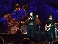 Turunen is seen singing, accompanied by a guitarist and drummer.