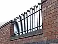 Iron railings with (metal) teddy bear heads, on the outside of the "Merrythought Village"