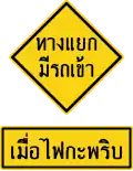An intersection sign has traffic when the lights flash.