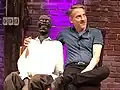 Bob Novella (right) with prop during a live show, 2019