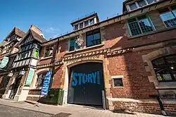 Image of the The Story Museum building frontage including the main double gates, which feature The Story Museum logo