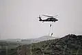 Two Turkish commandos propel from an S-70 utility helicopter in support of ground combat operations during the culminating event of Exercise Erciyes