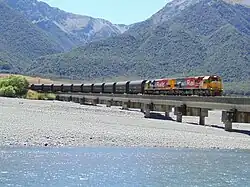 photo of two locomotives pulling a train over a bridge