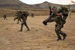 Students simulating moving comrades during a live fire exercise on Camp Pendleton.