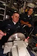 YN3 Joshua Jones, helmsman of the watch, maintains course and depth of USS Henry M. Jackson (SSBN-730). Diving officer of the watch Chief Fire Control Technician Troy Leonard looks on.
