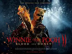 An angry humanoid Winnie-the-Pooh wields a chainsaw engulfed in flames in the middle of a forest.