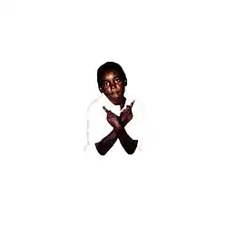 A boy with their forearms crossed with both hands giving the finger